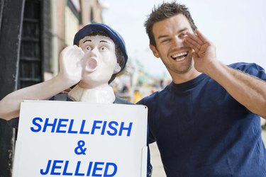Shop vendor imitating mascot by seafood shop