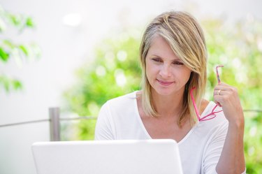 smiling woman working on a computer on her garden