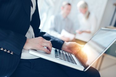 Woman with laptop and marketing team