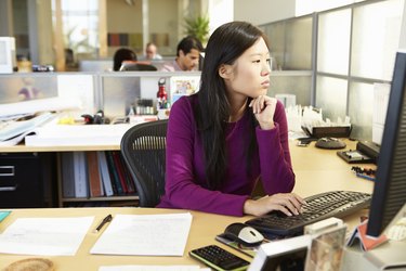 Asian Woman Working At Computer In Modern Office