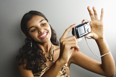 Young woman with camera taking picture of herself