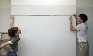 Couple measuring and marking a wall