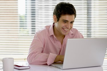 Smiling businessman using laptop