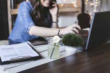 Beautiful hipster woman using laptop at modern office