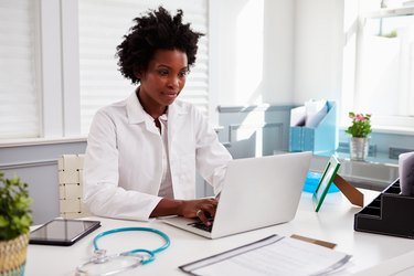 Black female doctor wearing white coat at work in