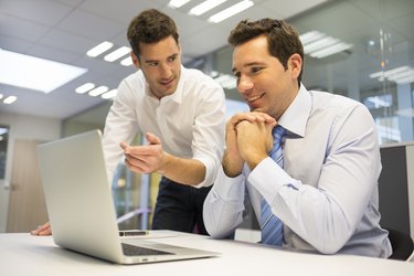 Two handsome businessmen working together on a project at office