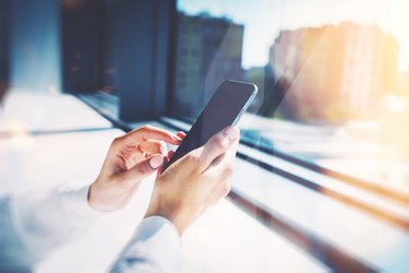 Girl touching a screen of her smarthone. Blurred background, horizontal