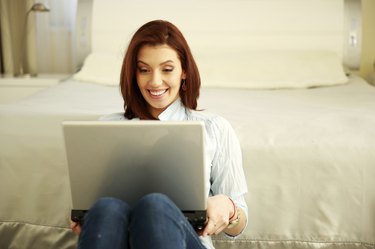 Happy woman sitting with laptop