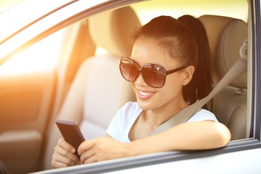 happy woman driver use her cell phone in car