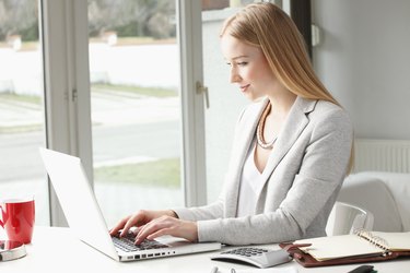 Attractive business woman is typing on her keyboard