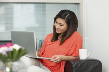 Asian woman at home working on a laptop