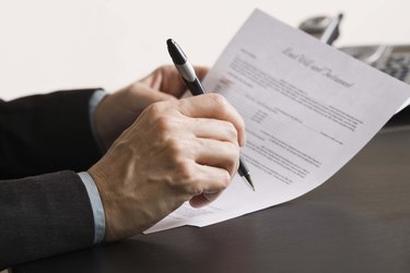 Person writing on paper documents