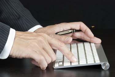 Businessman Pushes Enter On Computer Keyboard
