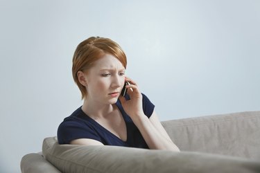 Woman talking on mobile phone on sofa