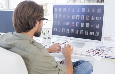 Photo editor looking at thumbnails on computer