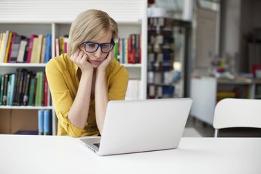 Overworked sad woman working in library