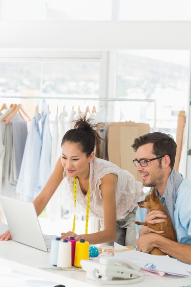 Fashion designers using laptop in studio