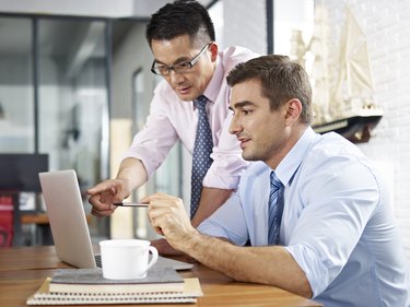 asian and caucasian businessmen working together in office