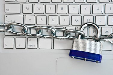 Close-up of padlock and chain around laptop computer