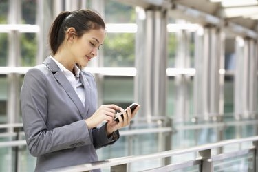 Hispanic Businesswoman Outside Office On Mobile Phone