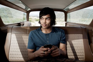 Young man inside car using smartphone