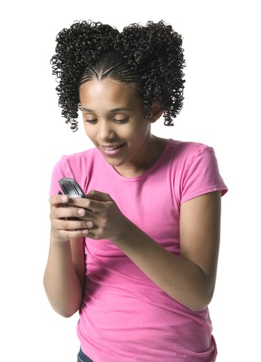 medium shot of a teenage female as she writes a text message on her cell phone