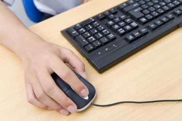 Hand on computer mouse, China, Beijing