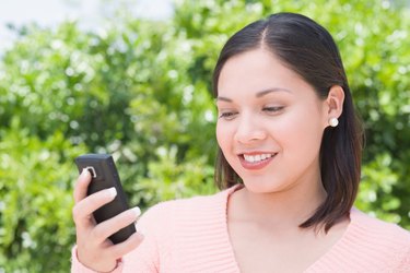 Woman outdoors holding cell phone