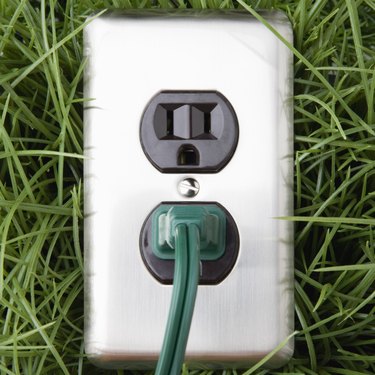 Electrical outlet in grass with power cord