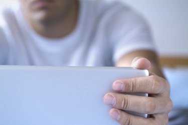 Close-up of a man's fingers opening a laptop