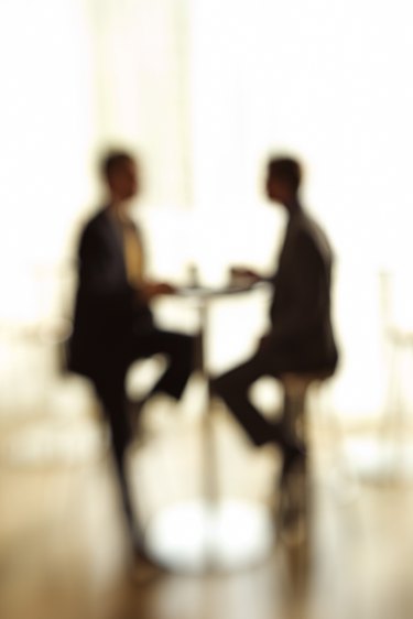 Blurred silhouette of businessmen at table