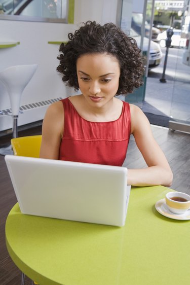 Woman using laptop at cafe