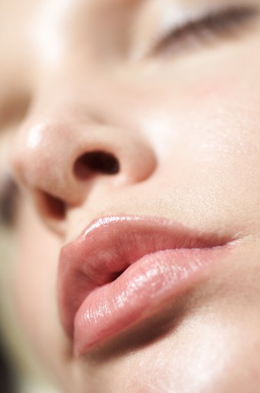 extreme close up of a young caucasian womans face as she pouts her lips
