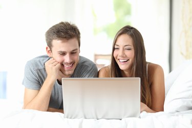 Couple watching videos on a laptop at home