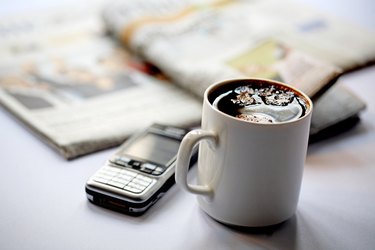 Close up of a coffee mug and cell phone