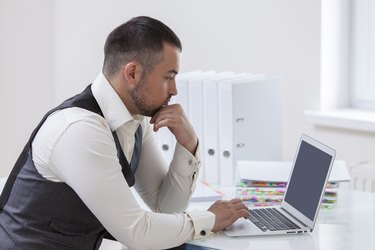 Young businessman using at laptop at desk