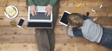 Mother and son using tablet and laptop