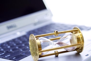 Close up of an hour glass on a laptop