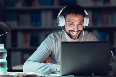 Smiling man networking late at night