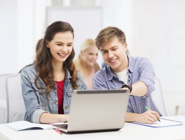 students with laptop and notebooks at school