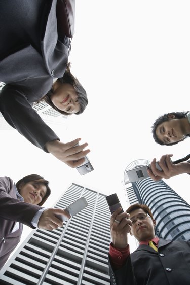 Low angle view of businesspeople with cell phones