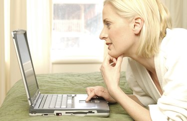 Woman using laptop computer in hotel room