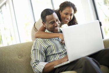 Affectionate Couple Using Laptop in Living Room