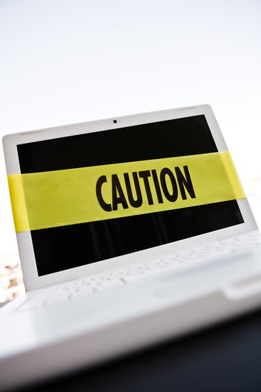Caution tape around laptop computer