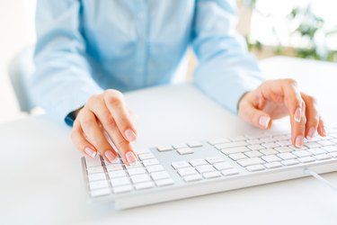 Woman office worker typing on the keyboard