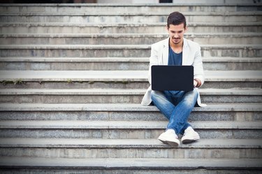 Man Sitting on the Stairs Using Laptop