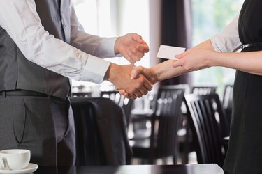 Busines people shaking hands after meeting and changing cards