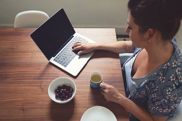 Horizontal overhead view of woman working on computer at home