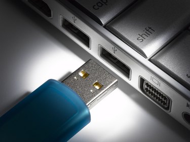 USB flash drive about to connect to laptop, close-up