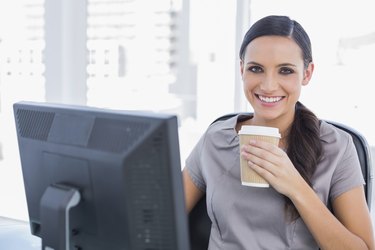 Attractive businesswoman drinking coffee and cheering